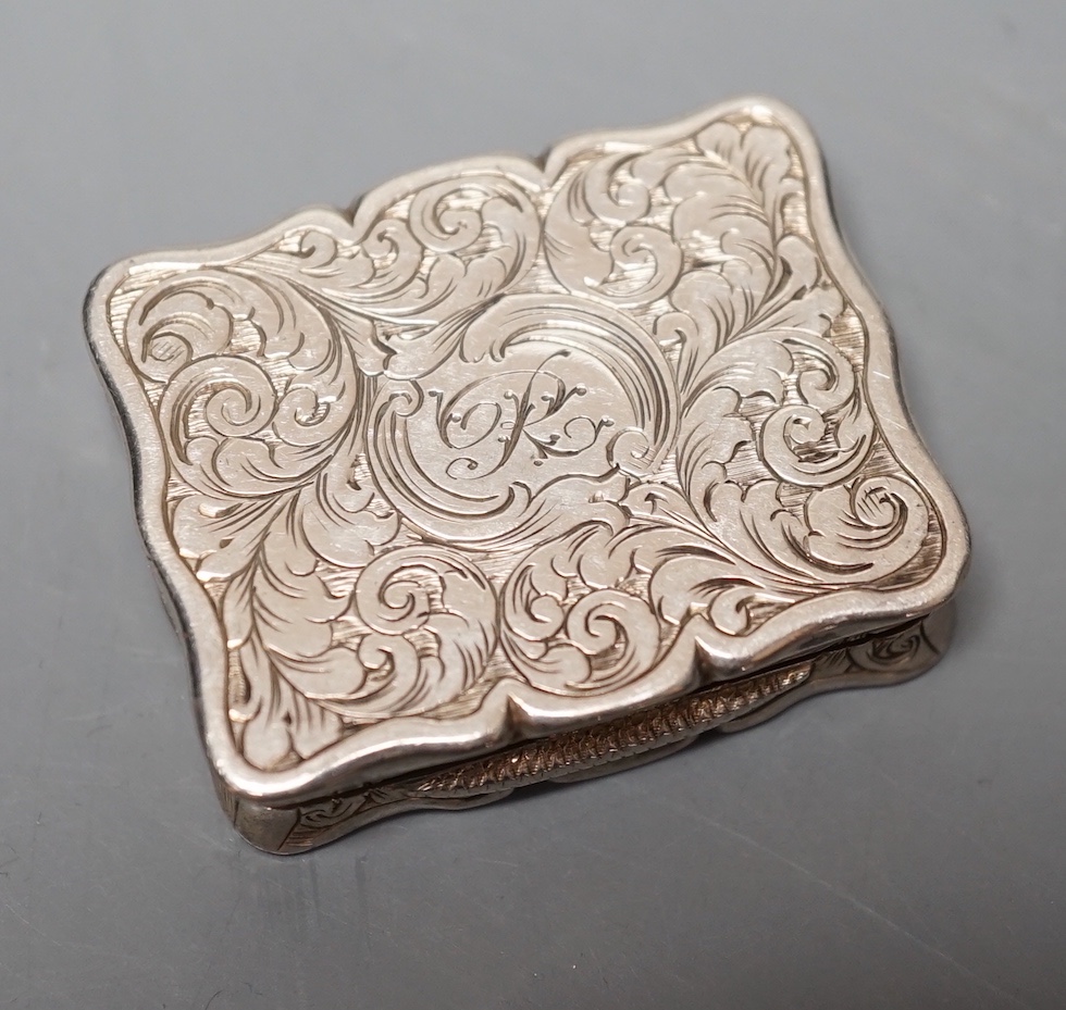 A Victorian silver shaped rectangular vinaigrette, engraved with landscape scene with river, Edward Smith, Birmingham, 1847, 38mm.